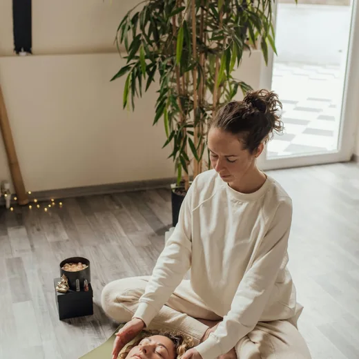 A practitioner kneeling beside a client at the start of a session