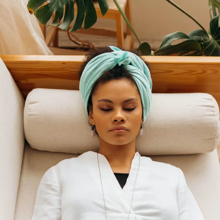A woman sitting quietly with one hand resting over her heart